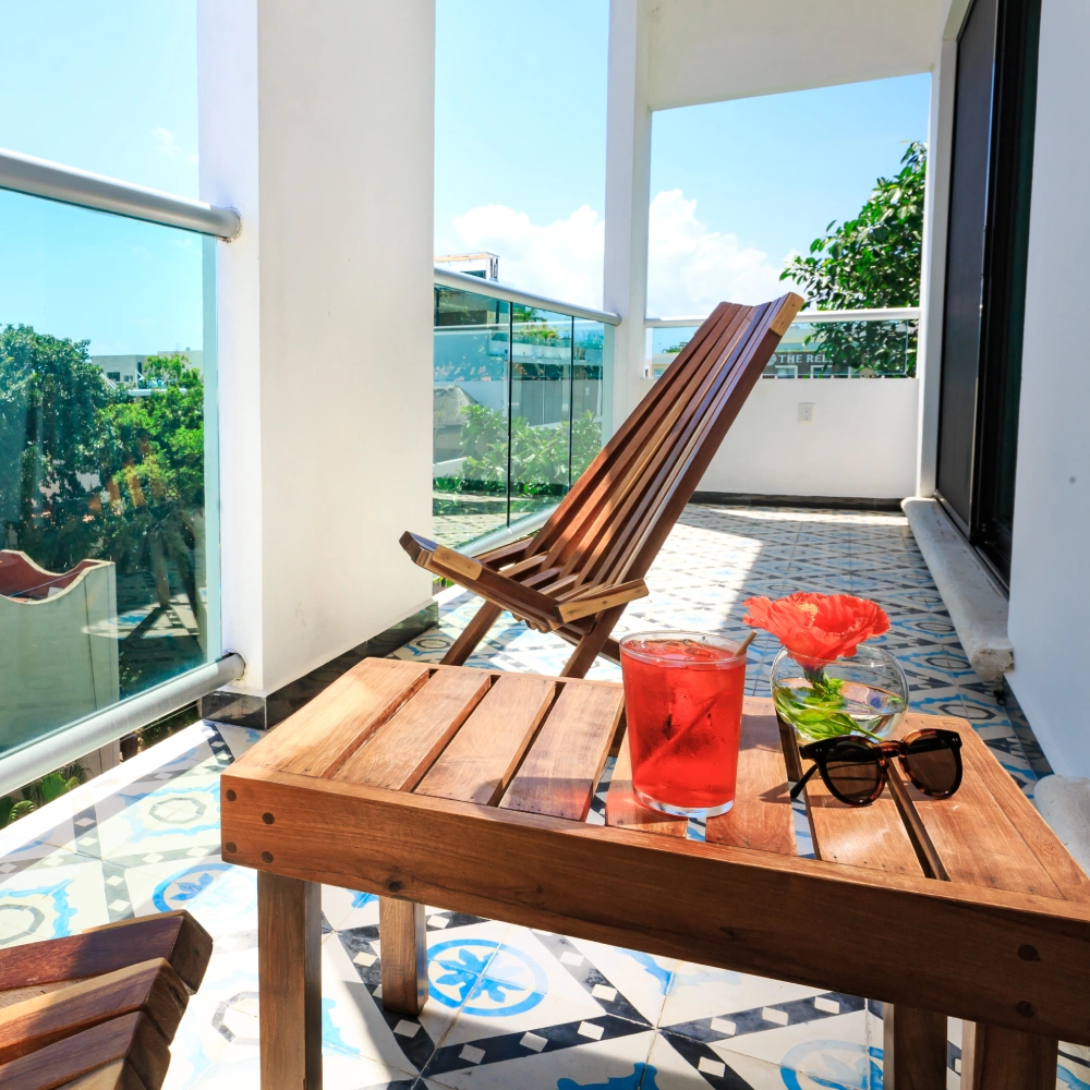 Terrace with wooden table, chair, red flower and glass on the balcony